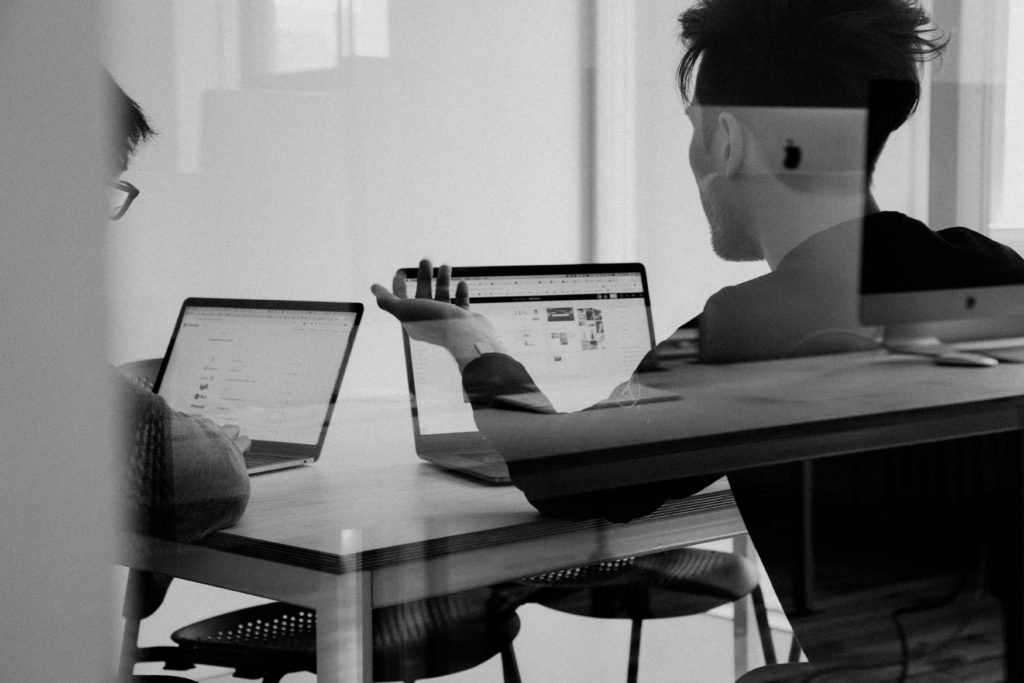 office workers behind glass wall working on digital signage