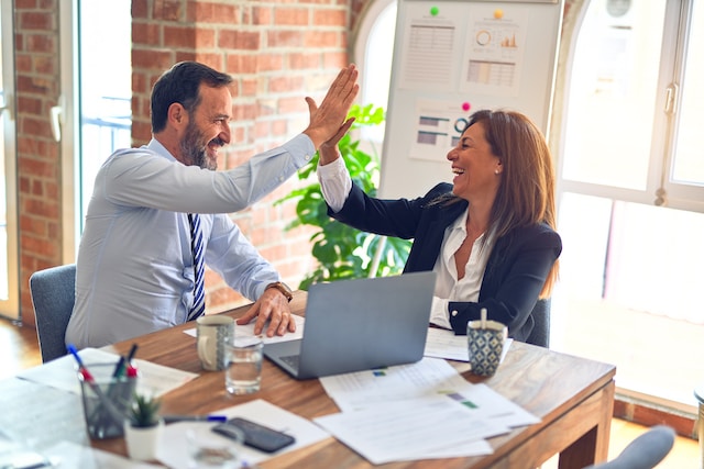 engaged employees high five at desk