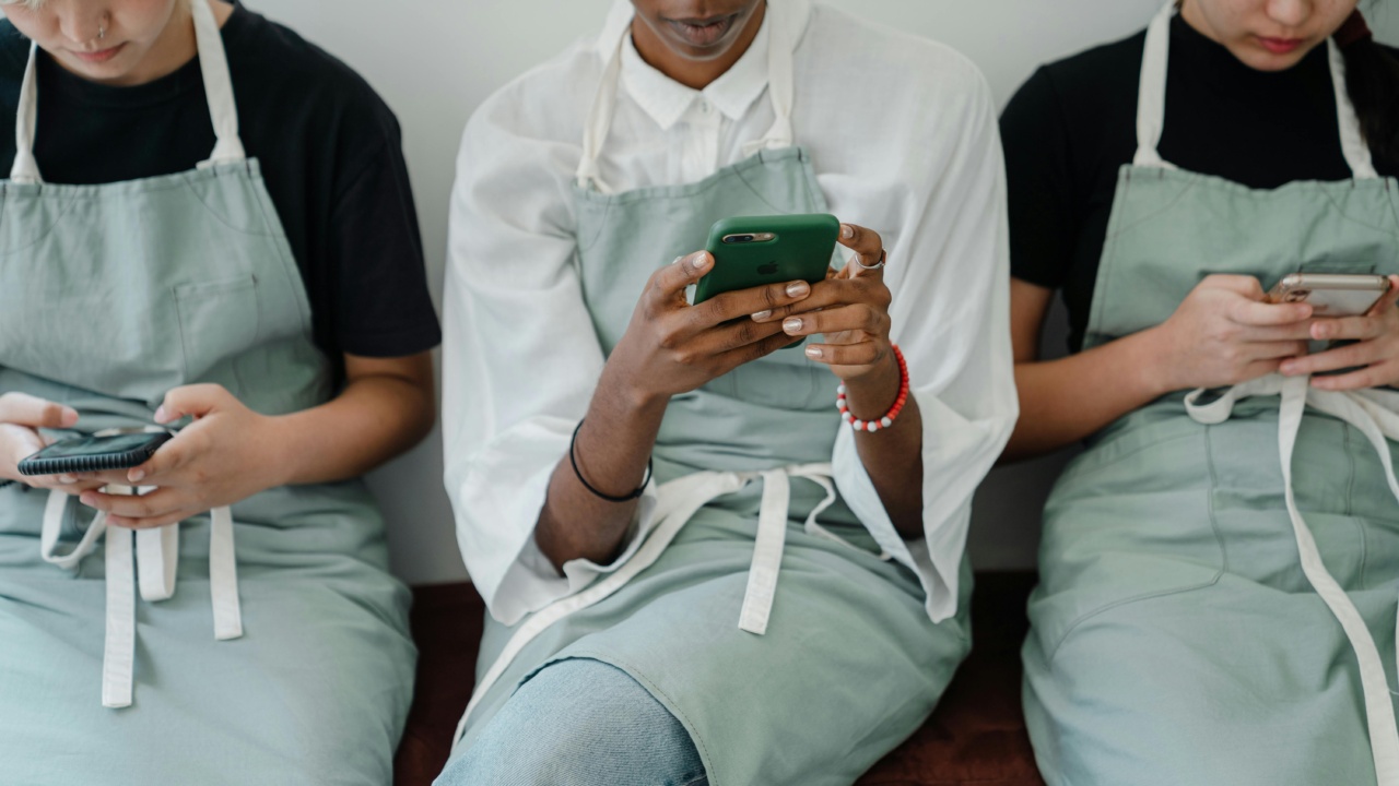 Frontline employees look at mobile newsletters created with an email newsletter tool